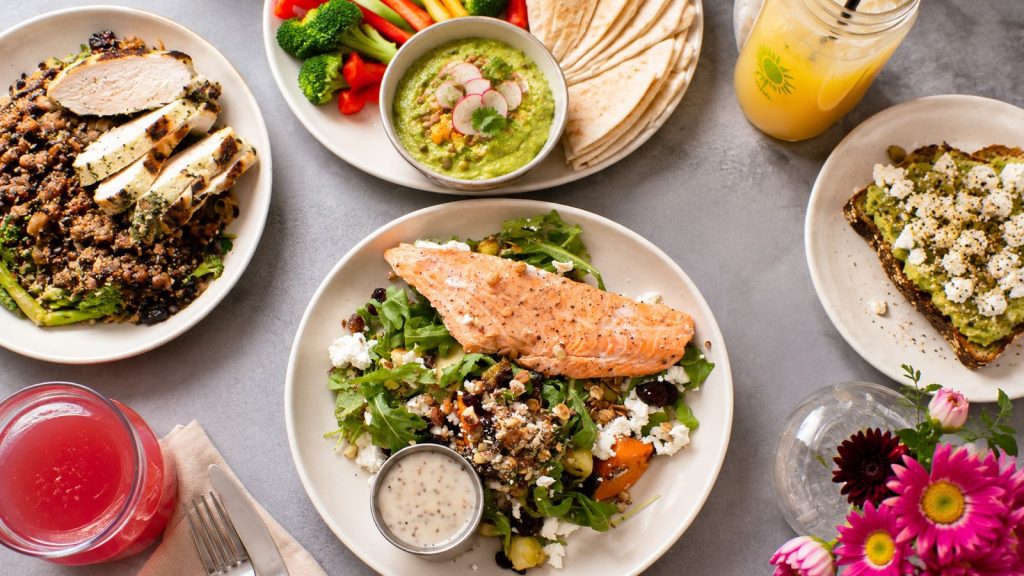 Healthy family meal with salmon, chicken, vegetables and wraps on the table